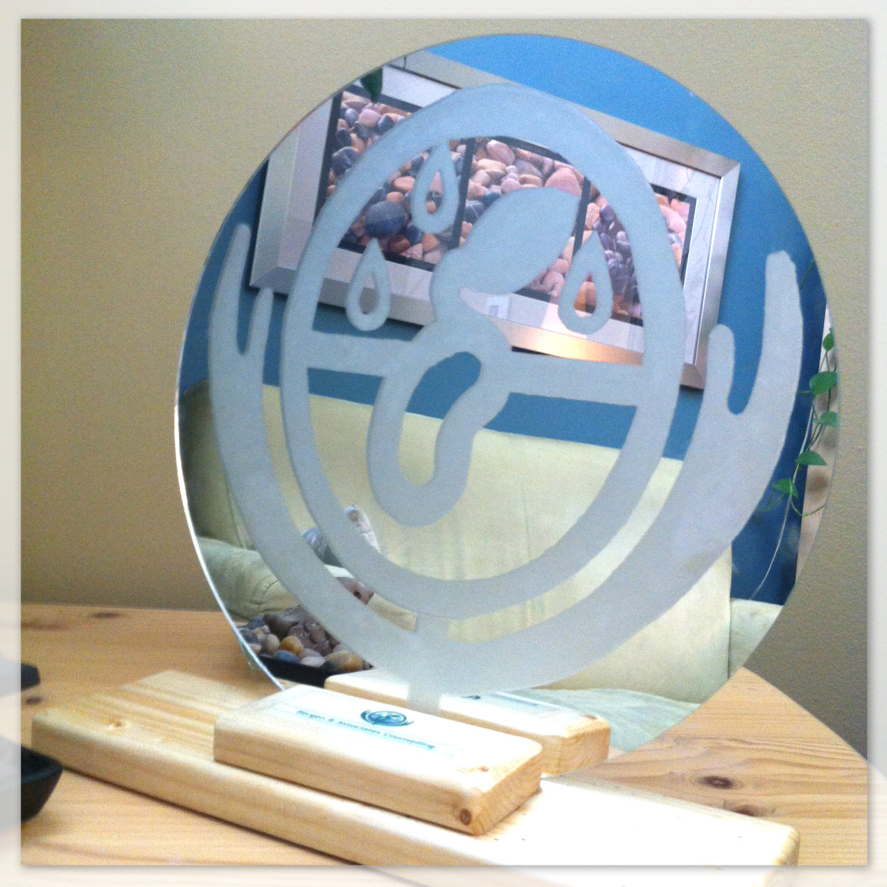Mirrored glass with intricate logo of Bergen and Associates Counselling in Winnipeg etched on it.